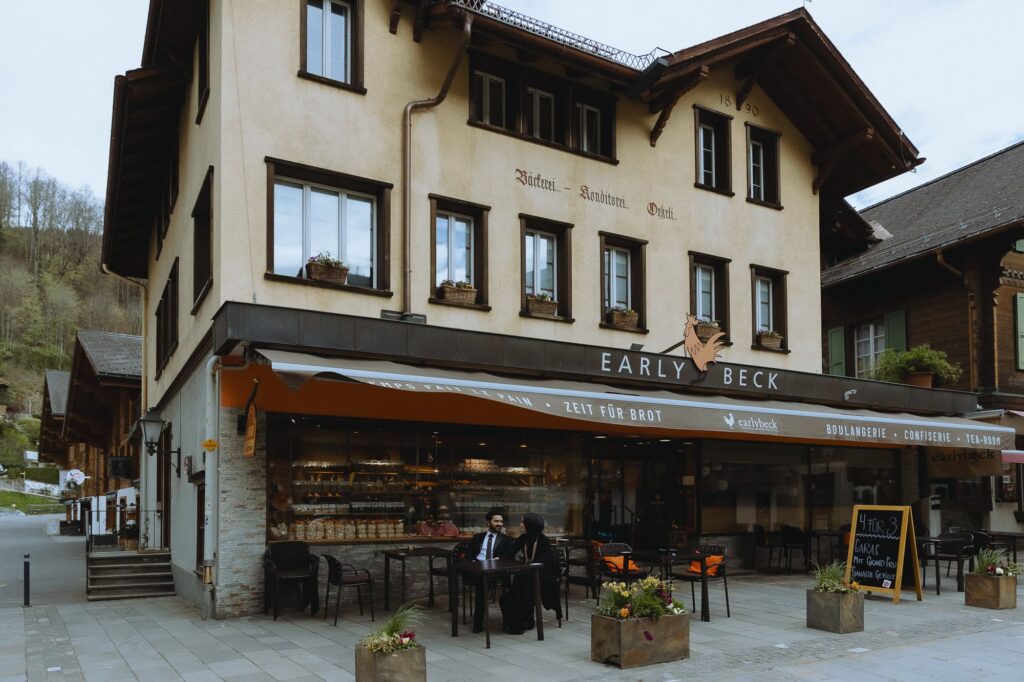 Couple seating in the terrace in front of the Early Beck bakery in Gstaad.