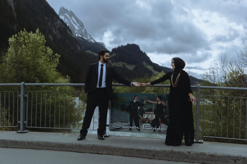 Couple holding hands on the bride with a DDLJ poster between them.