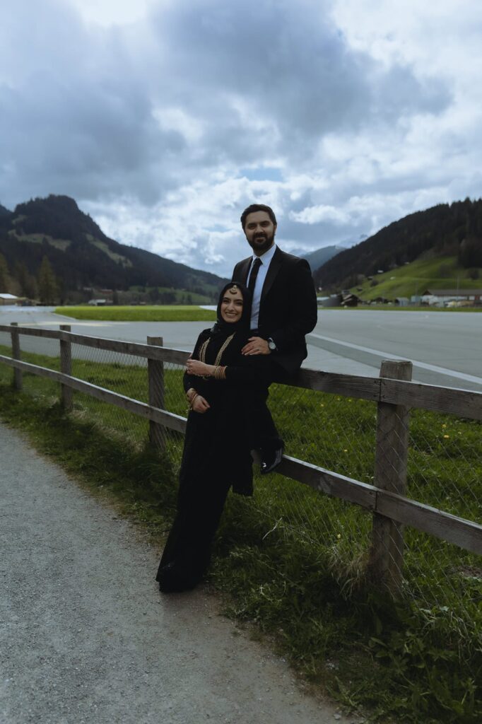 Couple standing on front of Saanen airport, one of DDLJ filming locations in Switzerland.