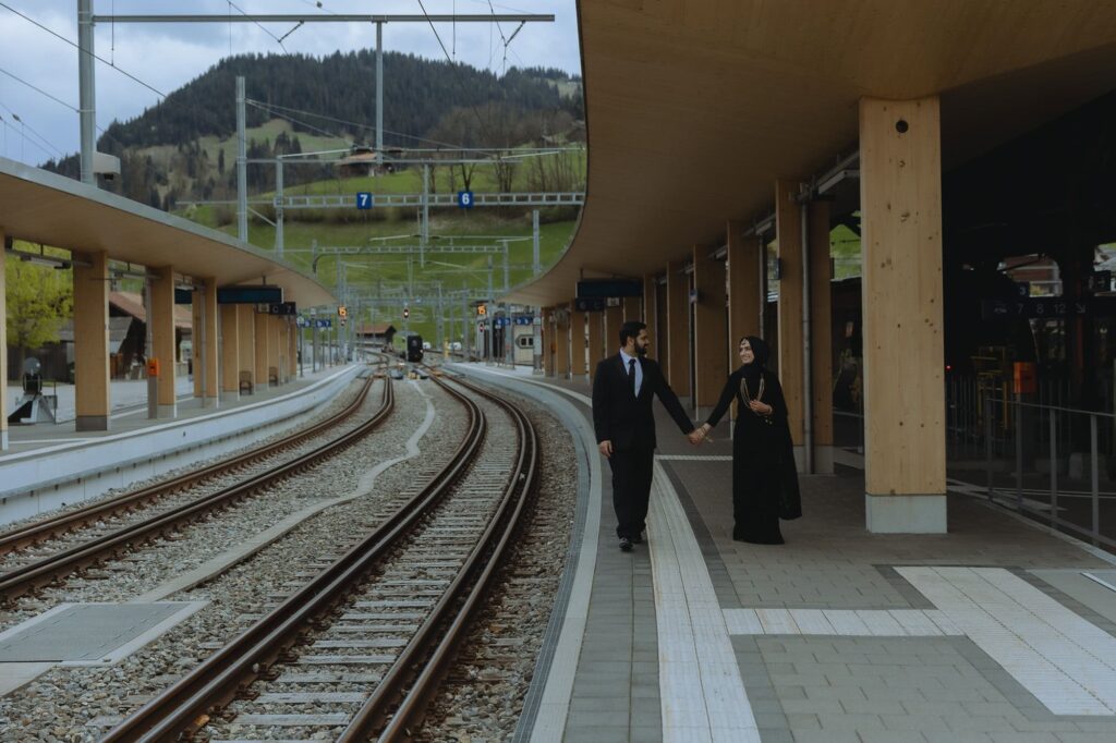 Couple walking on the platform in Zweisimmen, one of DDLJ filming locations in Switzerland.