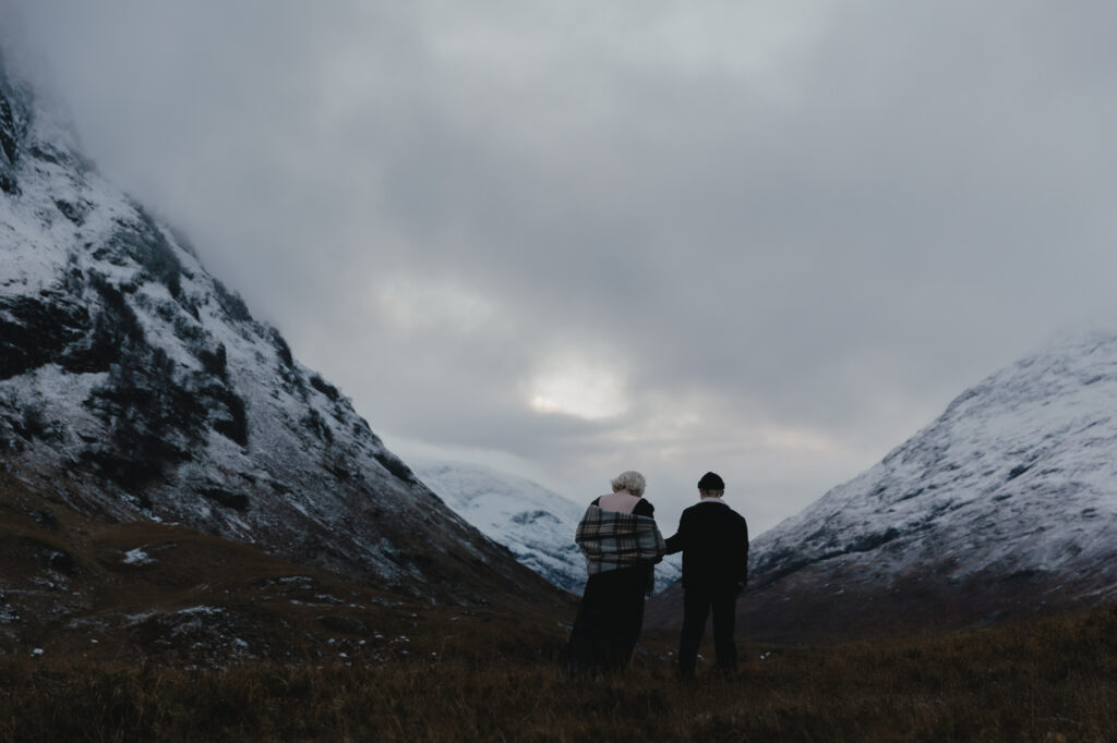 Couple walking in the scottish Highlands, during their winter adventure session.