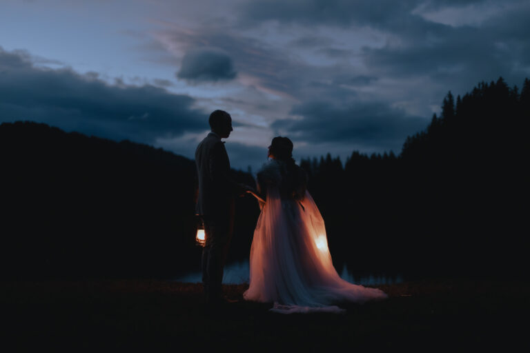 elopement couple standing next to each other at blue hour, holding lanterns.