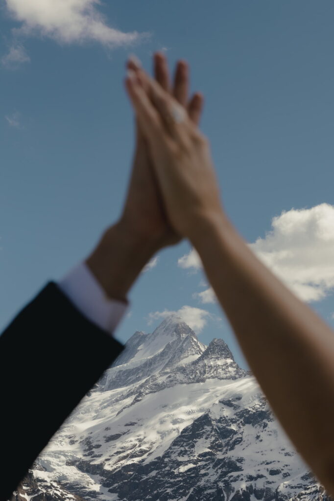 Blurry hands with a snowy mountain in the background.