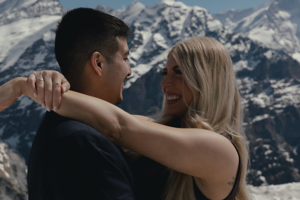 A close-up image of a couple smiling at each other during their winter proposal in Grindelwald.